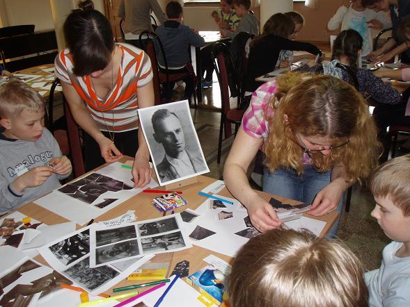 Dzieci z pomocą prowadzącej warsztaty i nauczycielki układają puzzle ze zdjęć rodzinnych rotmistrza Pileckiego