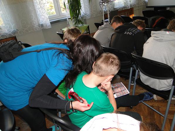 Gimnazjaliści oglądają zdjęcia z byłej katowni UB